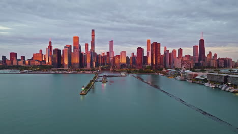 aerial tracking shot in front of the lakefront of chicago, colorful sunrise