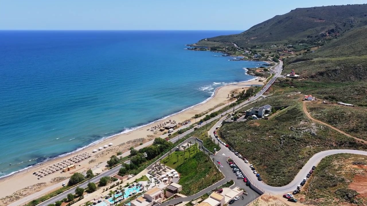 Bir yamaç tesisi ve dağların altında kumlu bir plaj ve turkuaz bir koyun drone ile havadan görünümü, Episkopi, Yunanistan