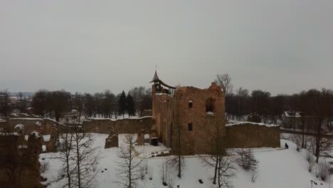 ruins of ancient livonian order's stone medieval castle latvia aerial drone top shot from above . restored castle capella at winter in dobele city. 4k resolution