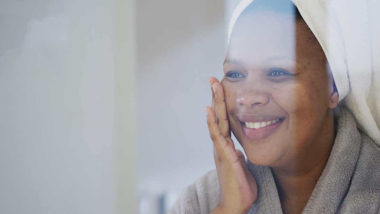 Happy african american plus size woman applying face cream, unaltered, slow motion