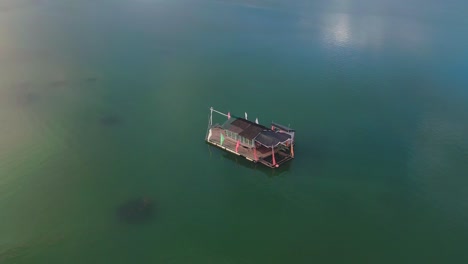 floating cottage in turquoise water with cloud reflection, philippines