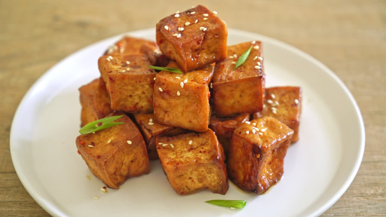 tofu frito con sésamo blanco y salsa teriyaki - estilo de comida vegana y vegetariana