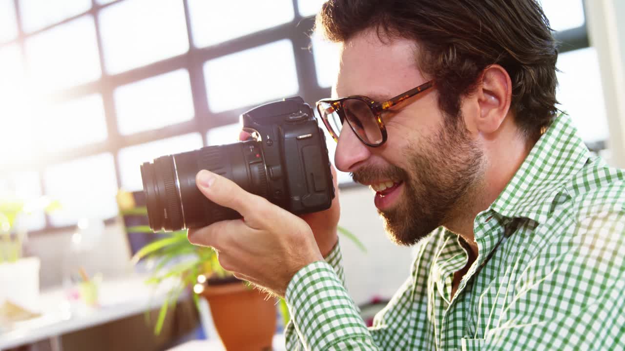 diseñador gráfico mirando imágenes en una cámara digital