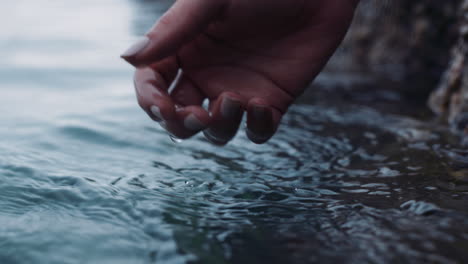 cerca de las manos tocando el agua refrescante corriente que fluye río dulce salpicando concepto de sostenibilidad