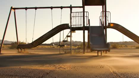 an abandoned playground slide and swingset in deserted landscape: capturing the essence of nostalgia and forgotten childhood memories in a quiet environment