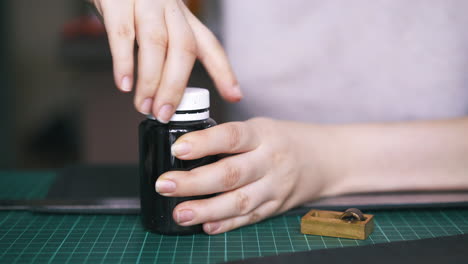 careful woman closes paint bottle and takes pure copper