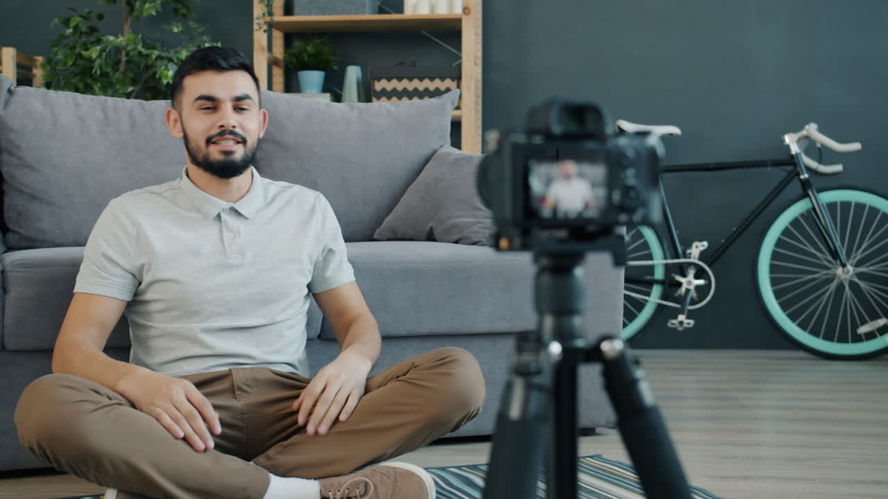 Man sitting on the floor doing a video call/vlog