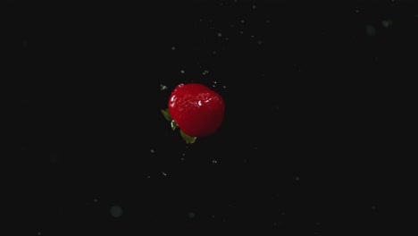 strawberries with water coming off of them in front of a backdrop in a studio