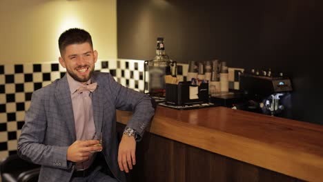 novio con una barba negra con un vaso de alcohol whisky en el bar. hombre de negocios