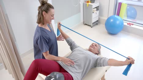 caucasian female physiotherapist and female senior patient with prosthetic leg exercising