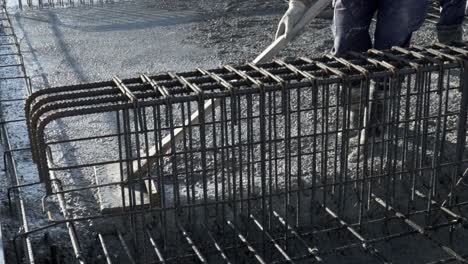 workers apply a layer of cement to create the floor and roof of a large area under construction