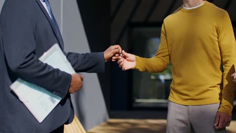 real estate agent handing over house keys to new homeowners