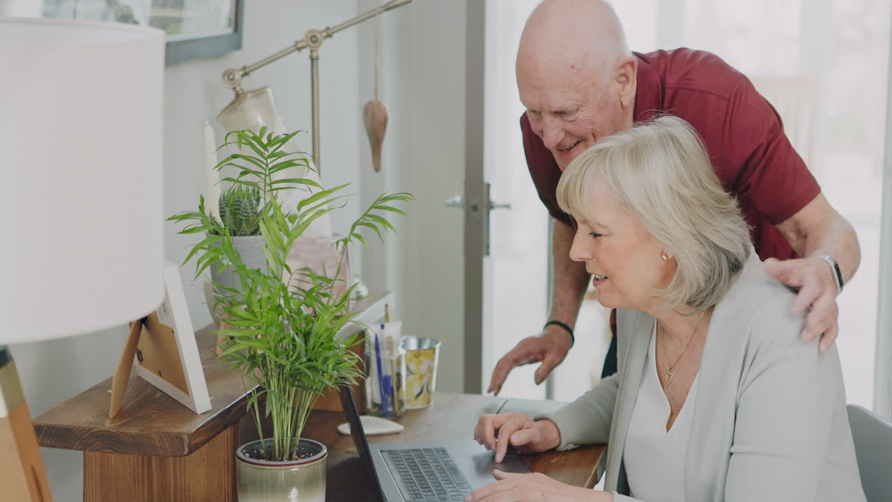An elderly couple using a laptop at home