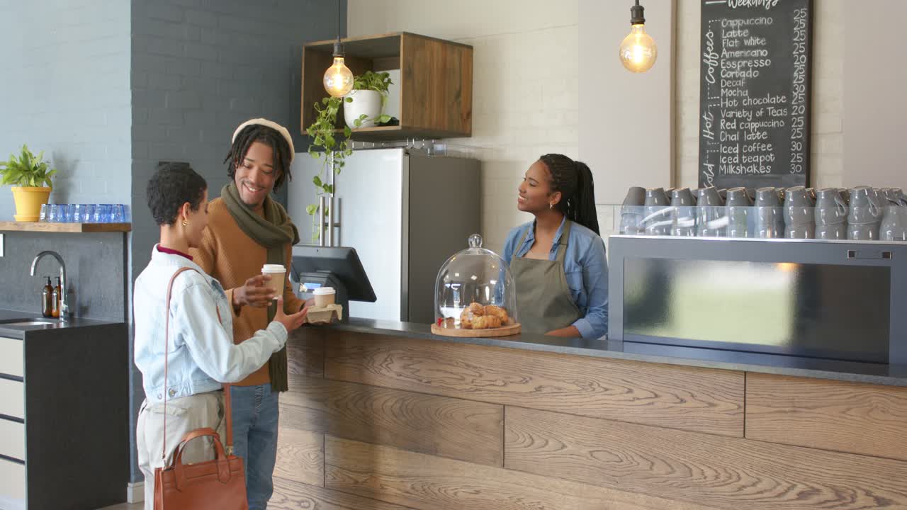 Entrando nel caffè, una coppia eterogenea ordina il caffè al bancone, il barista registra l'ordine e riempie le tazze.