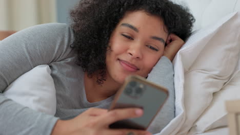 black woman lying bed, happy phone chat on social