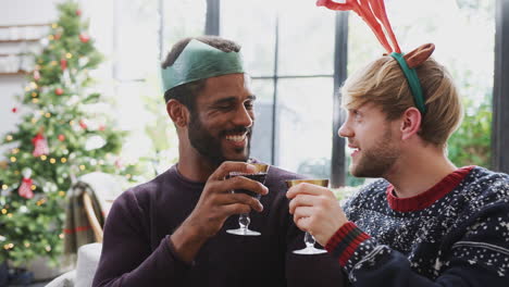 Homosexuelles-Männliches-Paar-Sitzt-Zum-Weihnachtsessen-Am-Tisch-Und-Macht-Toast