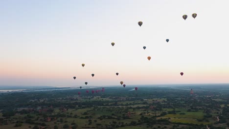 Toma-Aérea-De-Globos-Aerostáticos-Despegando-Al-Amanecer,-Bagan,-Myanmar.