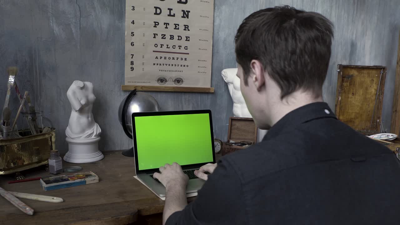 Person working on a laptop in an artist's studio