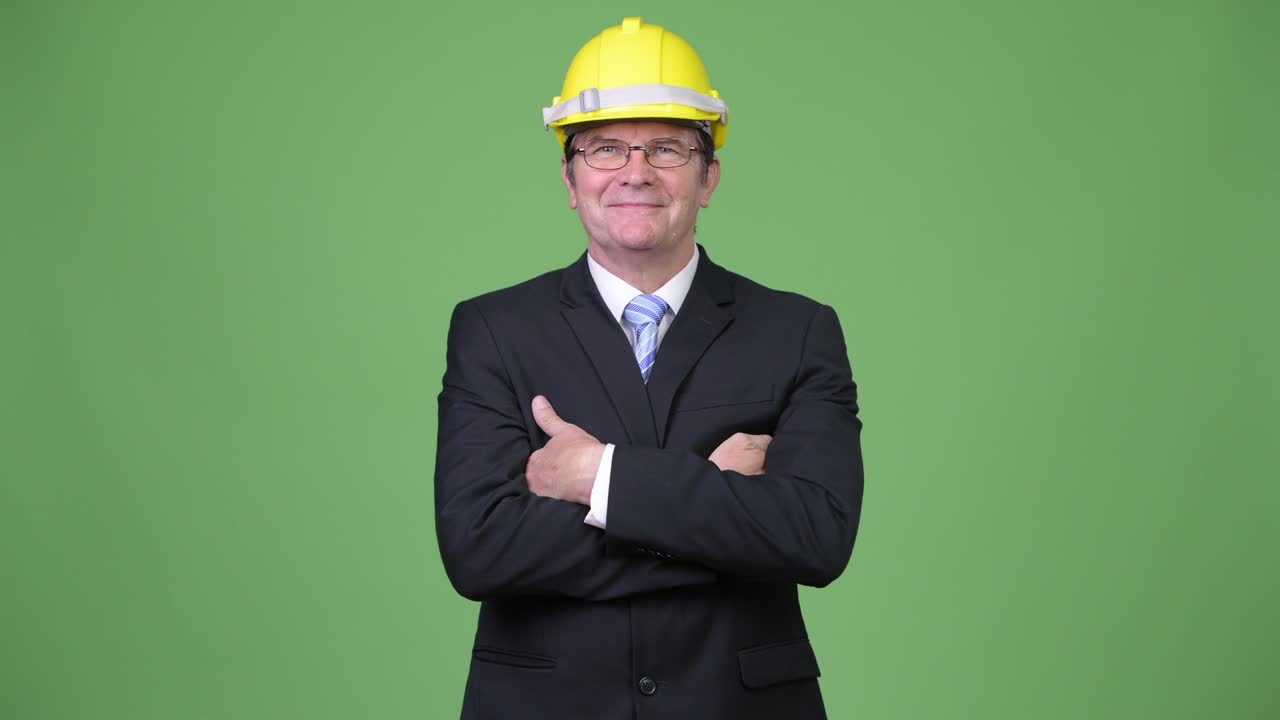 Senior handsome businessman as engineer with arms crossed