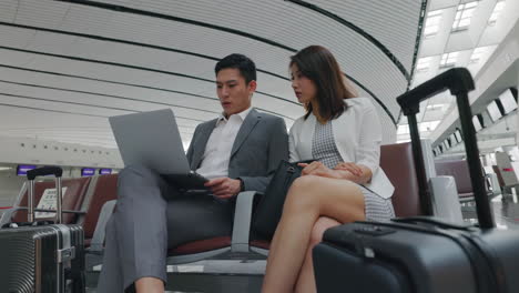 busy businessman businesswoman meeting strategy business team gathered in train lobby waiting room, discussing strategies for upcoming quarter, using laptops, charts to analyze data and make decisions