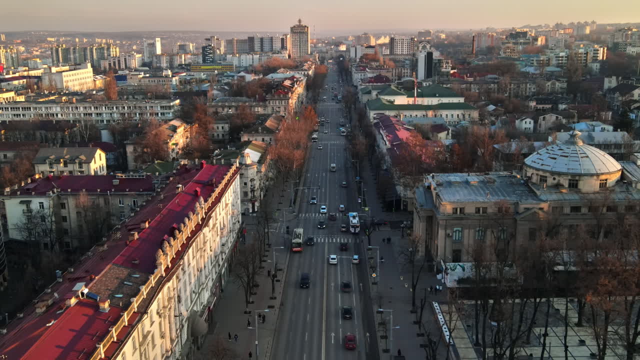 Aerial drone view of Chisinau downtown. Panorama view of a street with multiple buildings, road with moving cars and bare trees. Moldova