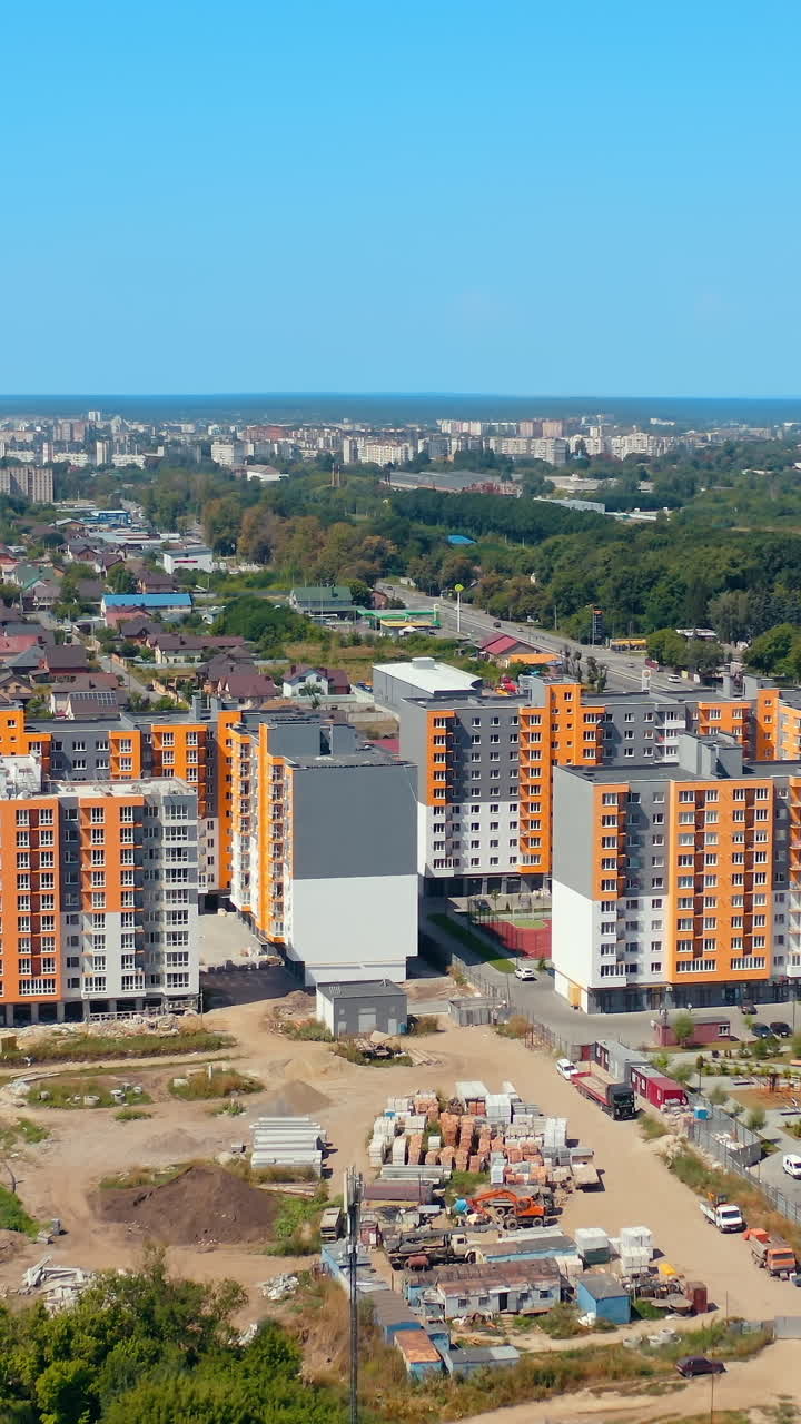 New housing apartments on urban background. Residential complex with high-rise buildings in new city area. Aerial view. Vertical video