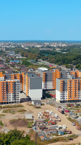 new housing apartments on urban background. residential complex with high-rise buildings in new city area. aerial view. vertical video