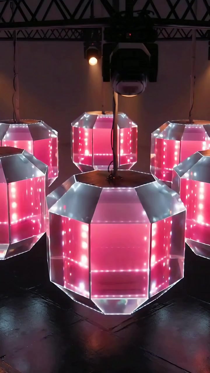 Vertical video: Lights cycling LED cluster shifting bicolor and pulsing in dark studio truss spot