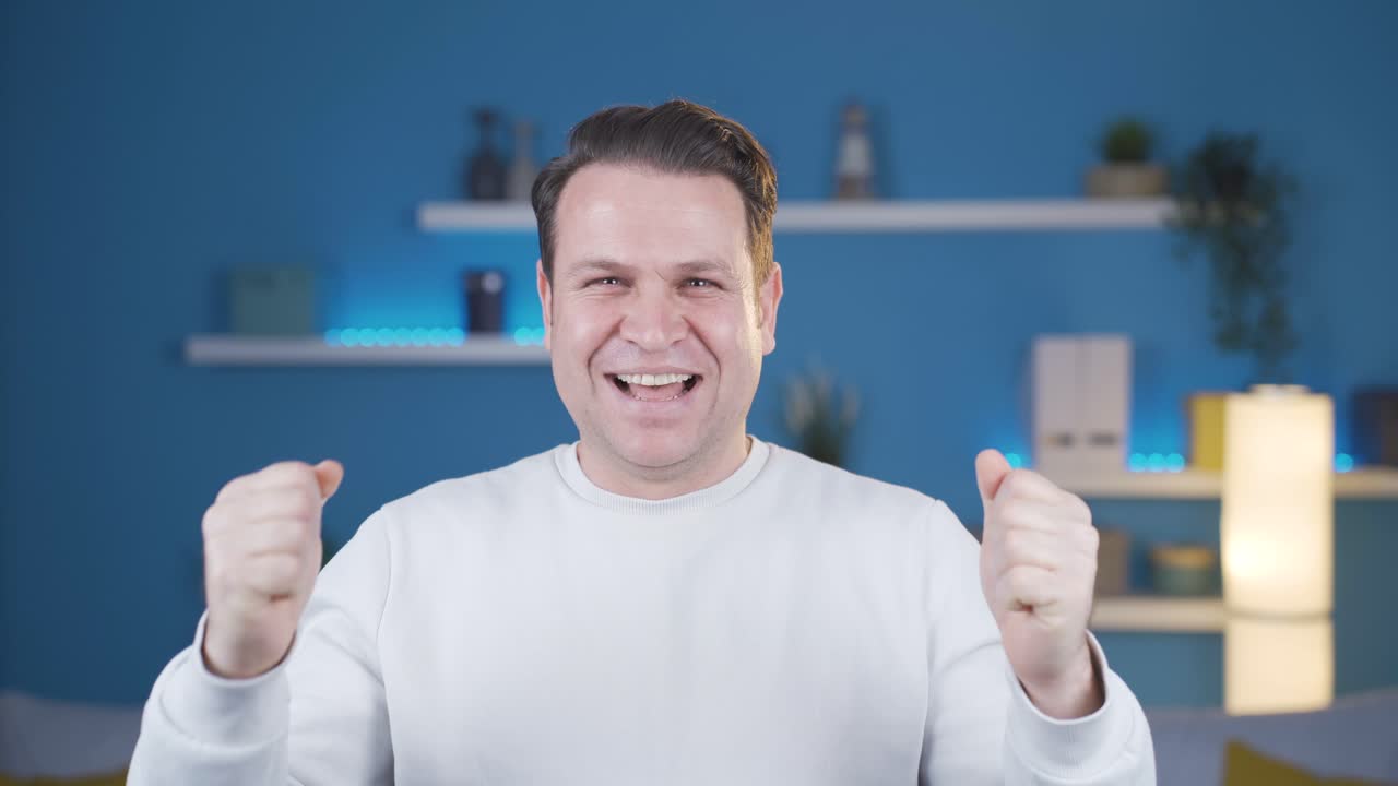 카메라를 보고 기 ⁇ 하는 그 남자는 매우 행복하고 열광적입니다.