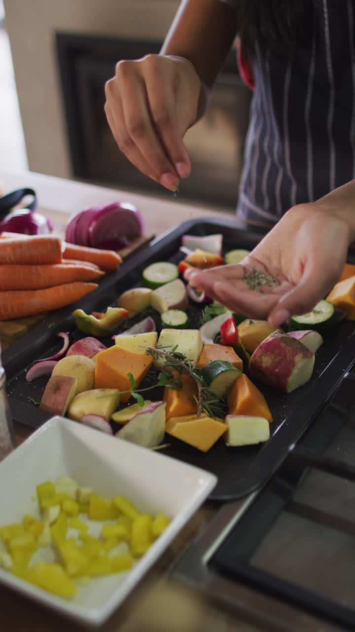 video vertical de la sección media de una mujer biracial aderezando verduras