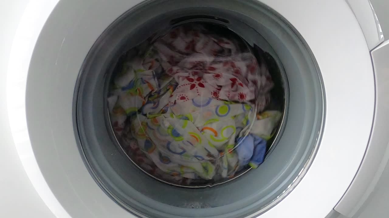 lavadora que trabaja con ropa en el interior