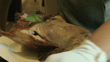 cortar la carne de un pavo recién cocinado en pedazos pequeños