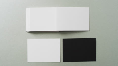 Overhead-view-of-blank-white-and-black-business-cards-on-grey-background,-copy-space,-slow-motion