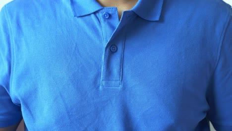 Man fastening a blue polo shirt