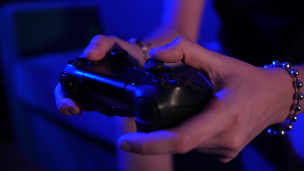Close Up of Hands Playing Video Game with Controller in Blue Light