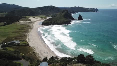 aerial shot, rising up focus on the beach, awana bay, great barrier island, new zealand