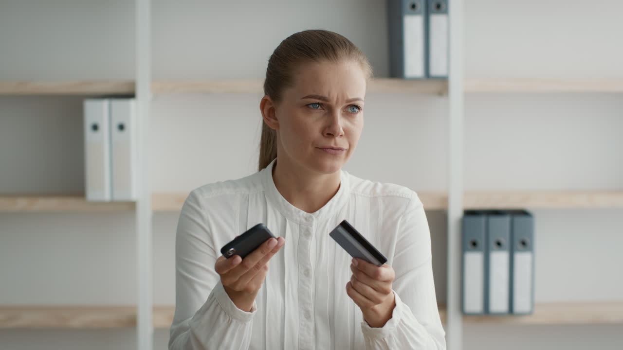 женщина проверяет кредитную карту и телефон для онлайн-платежей