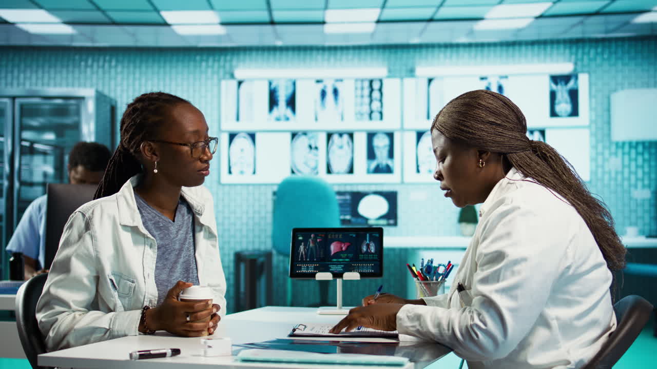Female general practitioner examining medical data with a patient