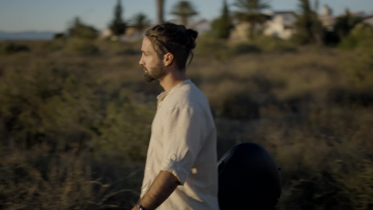 Man Walking with Guitar at Sunset by the Lake