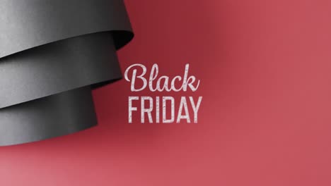 Animation-of-black-friday-text-over-rolled-up-black-paper-on-red-background