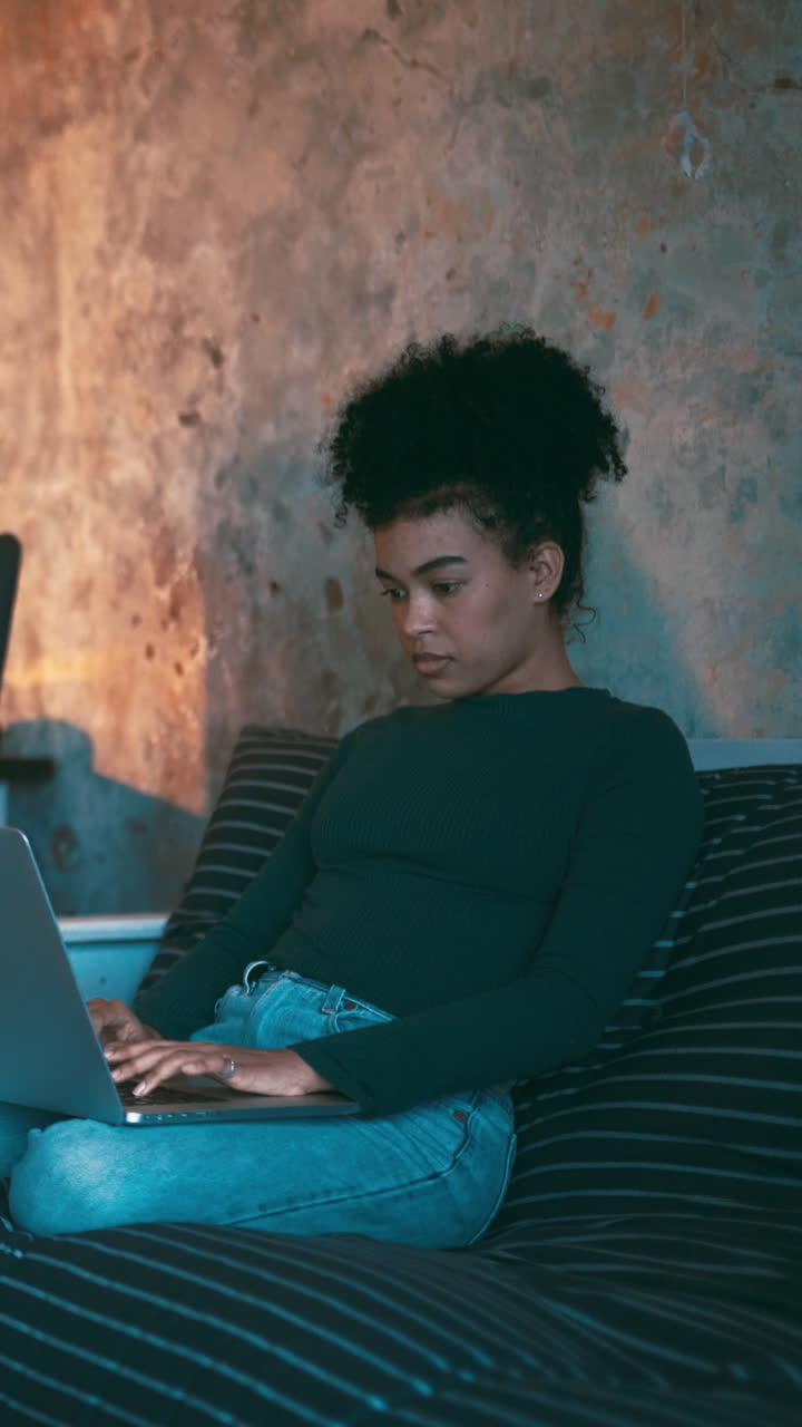 Young Woman Typing on Laptop While Sitting on a Couch