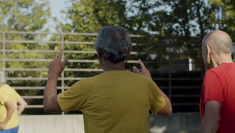 equipo de felices jugadores de fútbol senior abrazándose en círculo y celebrando el gol juntos