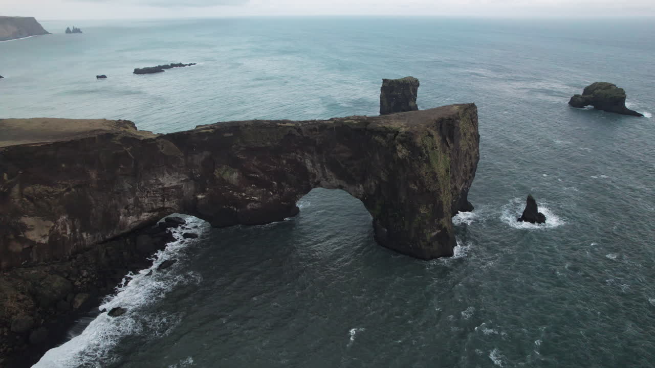 amplio paralaje aéreo alrededor del arco dyrholaey, o arco con el agujero, en islandia