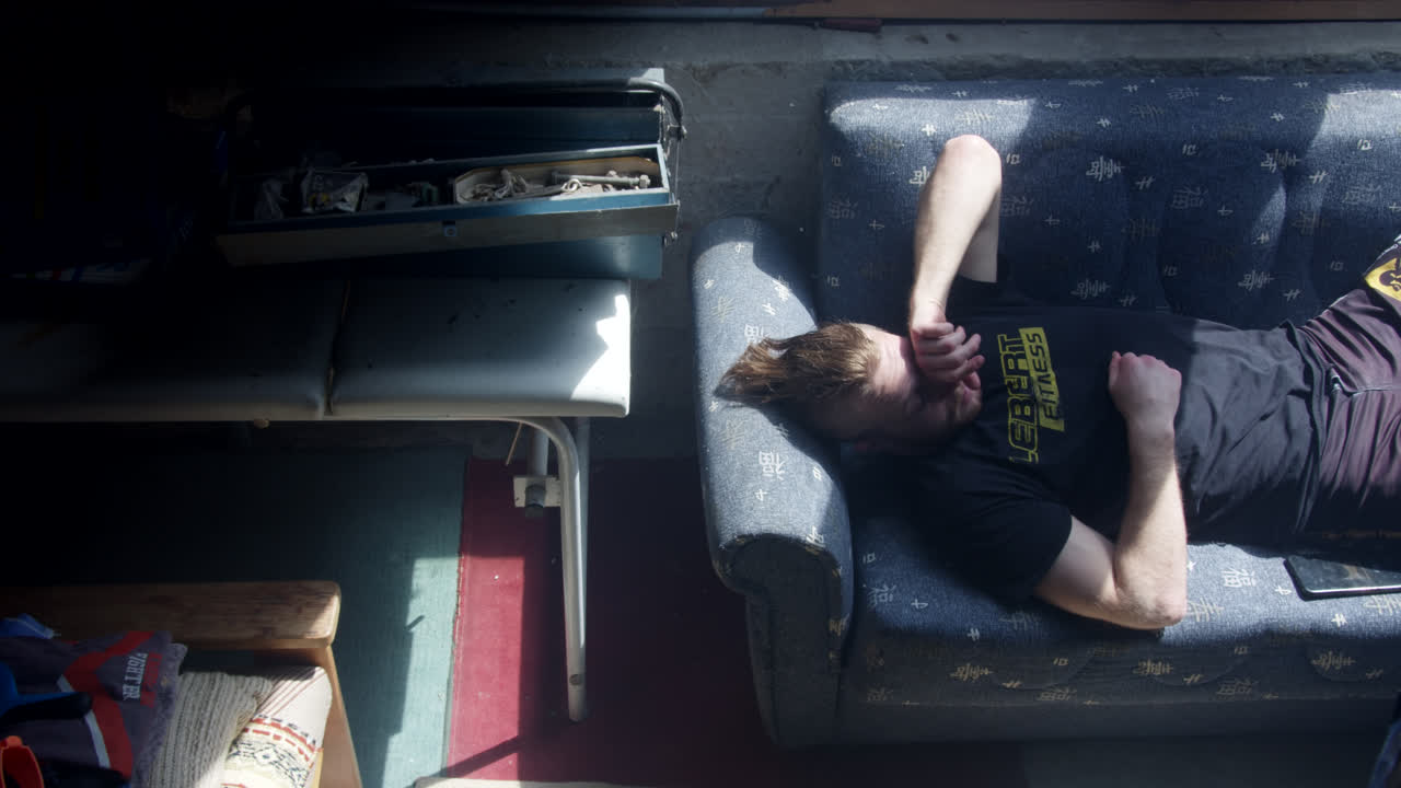 Man Relaxing on a Couch in a Workshop
