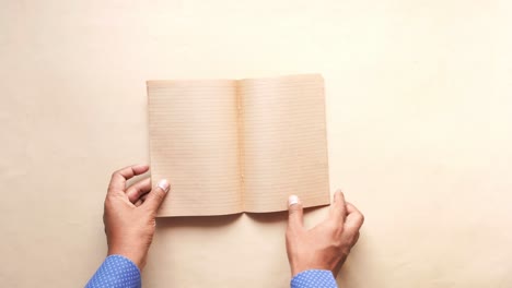 close up of mans hand turning a pager of a diary