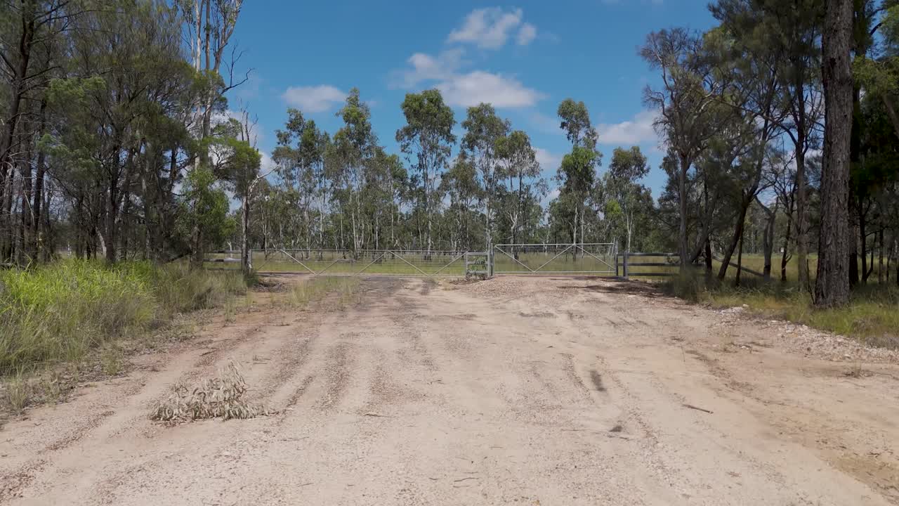 carretera rural con puerta y árboles