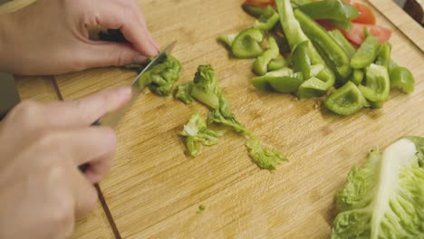 green juicy salad is cut into small pieces on a wooden cutting board