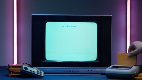 old television with blue screen on neon background. close-up of vintage tv and retro playstation, changing cartridges. antique video game, nostalgia