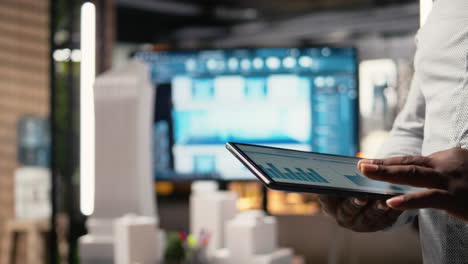 Close up of black professional uses architectural software on tablet
