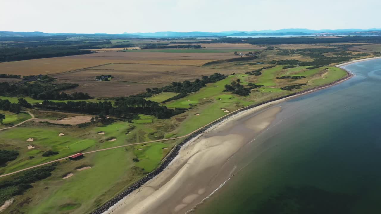 Aerial view of a coastal golf course next to a sandy beach and ocean